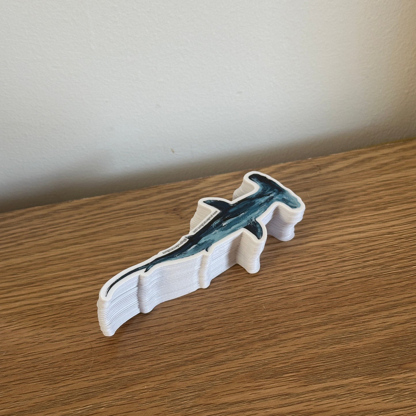 Sticker of a shark on a wooden surface